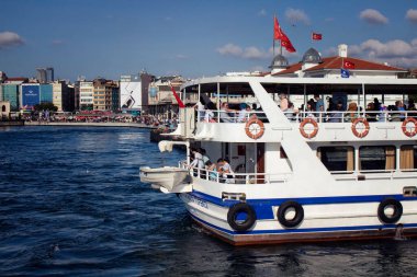 İstanbul 'un Asya yakasındaki Kadıköy halk feribot iskelesinden ayrılmak için motorlu bir teknede bekleyenler var. Güneşli bir yaz günü..