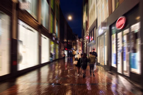 在阿姆斯特丹主要购物街之一的卡尔弗拉斯拉特大街上散步的年轻人惊慌失措的动作画面 这是一个下着雨的夏夜 青年文化概念 — 图库照片