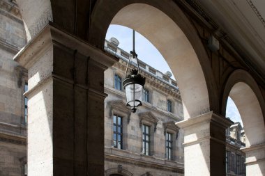 Eski, geleneksel sokak lambası Paris 'teki bir binanın kemerinde asılıydı. Gölgeler dramatik duygular yaratır.