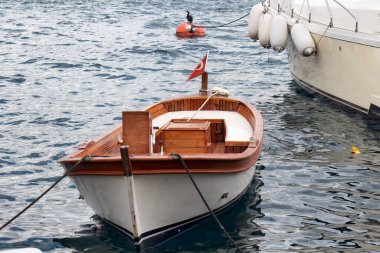 Boğazdaki Bebek Körfezi 'nde küçük bir balıkçı teknesi park etmiş. İstanbul 'da bulutlu bir sonbahar günü. Kano dalgalarının arkasında Türk bayrağı.