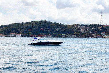 İstanbul 'da Avrupalı ve Asyalı taraflar arasında lüks yat / tekne Boğaz' ı geçiyor. Hava bulutlu bir sonbahar günü. Türkiye 'nin kuzeybatısında uluslararası alanda önemli bir su yolu bulunmaktadır.