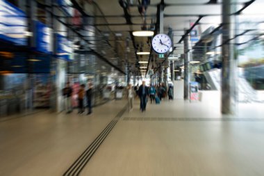 Amsterdam Centraal adlı ana tren istasyonunda yürüyen insanların bulanık görüntüsü. Büyük bir uluslararası demiryolu merkezi, günde 162 bin yolcu tarafından kullanılıyor. Ulaşım kavramı.