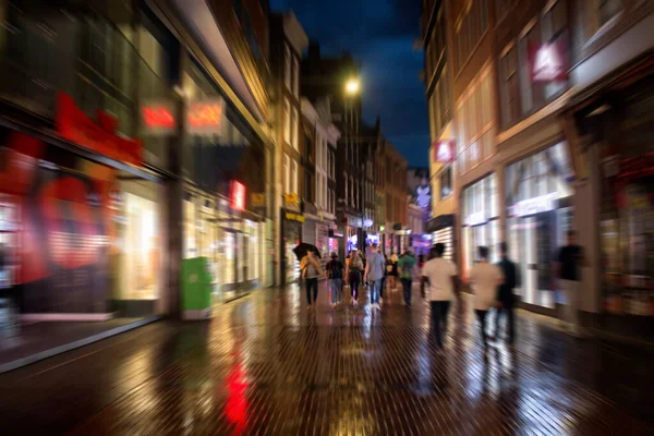 在阿姆斯特丹主要购物街之一的卡尔弗拉斯拉特大街上散步的年轻人惊慌失措的动作画面 这是一个下着雨的夏夜 青年文化概念 — 图库照片