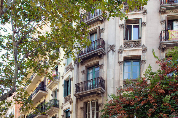 Close up view of traditional, historical, typical residential building in Barcelona showing Spanish architectural style. Catalan flag is hung at a balcony. t is a sunny summer day.