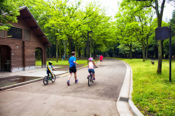 Father and children run and enjoy in nature at Yoyogi park in Tokyo