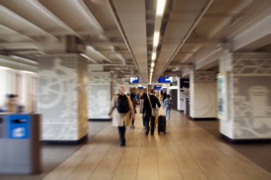 Amsterdam Centraal adlı ana tren istasyonunda yürüyen insanların bulanık görüntüsü. Büyük bir uluslararası demiryolu merkezi, günde 162 bin yolcu tarafından kullanılıyor. Ulaşım kavramı.