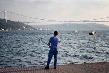 İstanbul 'da Boğaziçi' nin balıkçısı. FSM köprüsü arka planda.