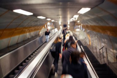 İstanbul metrosunda yürüyen merdivendeki insanların bulanık görüntüsü.