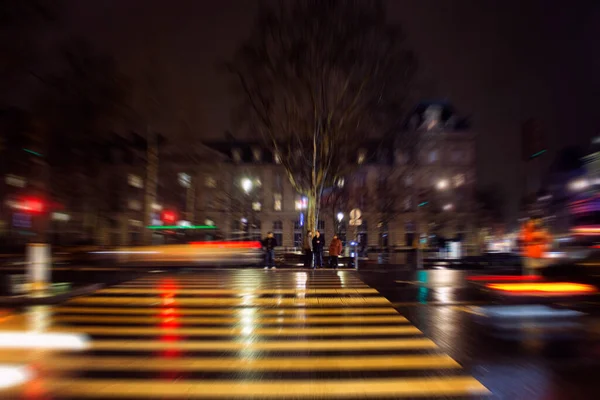 stock image Blurry motion image of people waiting to cross at lights in Republique square at night in Paris.