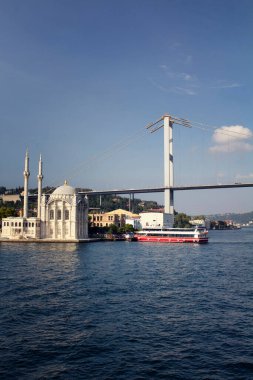 İstanbul 'un İstanbul' un eski ve tarihi Ortakoy Camii, tur teknesi, köprüsü ve Avrupa yakasının manzarası.