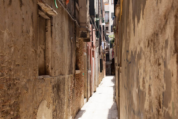 View of a narrow street with old, historical buildings in Venice / Italy.