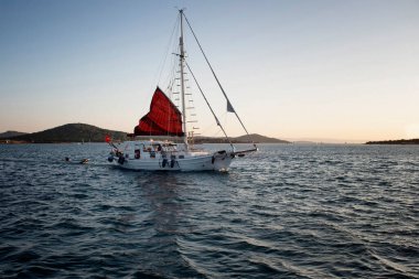 Günbatımında Cunda 'daki (Alibey) Ege Denizi' nde bir yelkenli manzarası.
