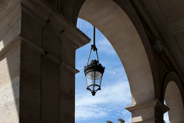 古い伝統的な街灯がパリの建物のアーチに掛けられていました 影が劇的な感情を生み出す — ストック写真