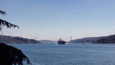 İstanbul 'un Avrupa ve Asya taraflarındaki Boğaz Köprüsü' nde büyük kuru bir kargo gemisi görülüyor. Güneşli bir yaz günü..