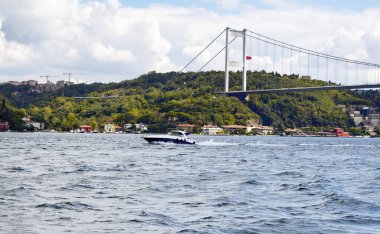 İstanbul 'da Avrupalı ve Asyalı taraflar arasında lüks yat / tekne Boğaz' ı geçiyor. Arka planda FSM (Fatih Sultan Mehmet) köprüsü var. Türkiye 'nin kuzeybatısında önemli bir su yolu bulunmaktadır.