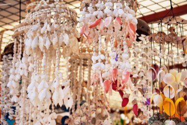 Türkiye 'nin Bodrum şehrinde midye, deniz tarağı, yengeç, istiridye ve gastropod kabuklarından yapılan el yapımı rüzgar çanları. Görüntü Ege ve Akdeniz kültürünü ve yaşam tarzını yansıtıyor.