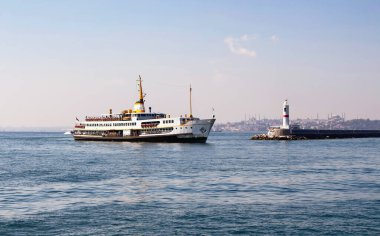 İstanbul 'daki Kadıköy istasyonuna geleneksel feribot geliyor. Manzarada su kırıcı da var. Arka planda Ayasofya ve Mavi Cami var..