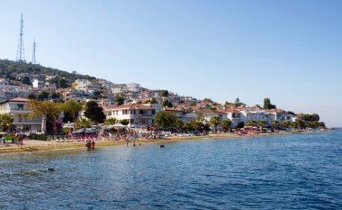 Prens Adaları 'ndan biri olan Kinaliada' daki sahil manzarası İstanbul 'da Adalar olarak da bilinir. Yazlık evler ve güneş banyosu yapan insanlar manzarada. İstanbul 'a en yakın yer orası.