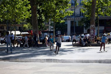 Gençler Paris 'teki Cumhuriyet Meydanı' nda (Place de la Republique) kayıyorlar. Görüntü şehrin gençlik kültürünü gösteriyor..