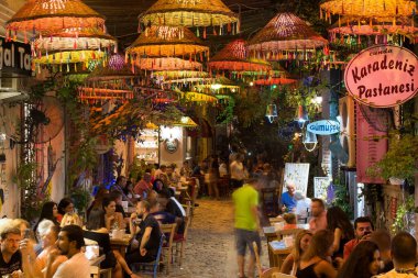 Eski Cunda (Alibey) adasının dışındaki kafelerde sosyalleşen insanların uzun süredir görüntüsü bulanık. Görüntü bölgenin yaşam tarzını ve kültürünü gösteriyor.