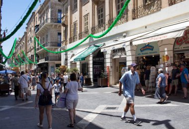İnsanlar Valletta City / Malta 'nın ana alışveriş caddelerinden birinde yürüyor.