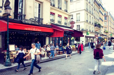 Paris 'teki ünlü Montorgueil Sokağı' nda insanlar yürüyor. Arka planda geleneksel bir kafe / bistro yeri var..