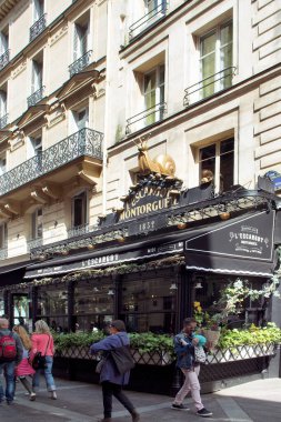 Paris 'te bir Fransız restoranının önünde yürüyen insanların görüntüsü.