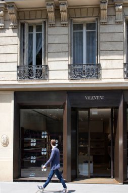 Paris 'in Le Marais semtinde lüks moda markalarından birinin dükkanının önünde bulanık hareketlerle yürüyor.