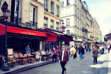 Paris 'teki ünlü Montorgueil Sokağı' nda insanlar yürüyor. Arka planda geleneksel bir kafe / bistro yeri var..