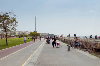 İstanbul Boğazı 'ndan yürüyen ve güneşli havanın keyfini çıkaran insanların görüntüsü. Görüntü, İstanbul 'un Asya yakasında yer alan Moda Mahallesi' nde çekildi..