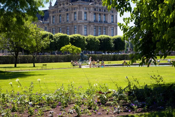 パリのJardin Des Tuileriesでは 男性と女性が日光浴をしています 像も見えます — ストック写真