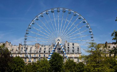 Paris 'teki Jardin Des Tuileries' de dönme dolap, ağaçlar ve binalar görünüyor..