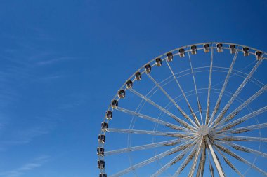 Paris 'teki Jardin Des Tuileries' de mavi gökyüzü arka planlı dönme dolabın yarısı görünüyor..