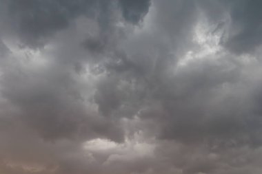 Ufuktan süzülen soluk altın ışıkla gökyüzünde toplanan kara fırtına bulutlarının dramatik görüntüsü karamsar ve yoğun bir atmosfer yaratıyor..