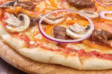 Mantar, et ve soğan ahşap plaka üzerinde yakın çekim pizza