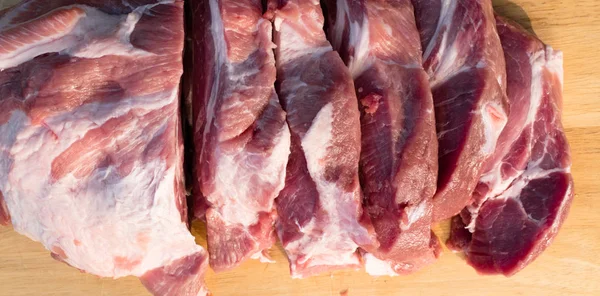 木製の背景に豚肉の生脂肪カッティング部分 新鮮な骨なし豚肉 首の部分や襟の部分 木製の背景に赤い生肉の大きな部分 — ストック写真