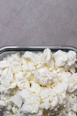 gri arka plan üzerinde cam kase süzme peynir