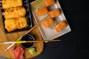 Suşi peynir, somon, karides, avokado, salatalık ile karışımı. Japonya gıda yemek çubukları, zencefil, wasabi, ahşap tahta üzerinde soya sosu ile. Sushi Menüsü