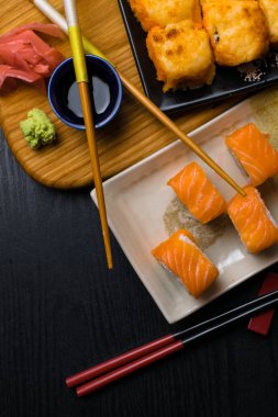 Suşi peynir, somon, karides, avokado, salatalık ile karışımı. Japonya gıda yemek çubukları, zencefil, wasabi, ahşap tahta üzerinde soya sosu ile. Sushi Menüsü