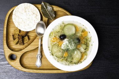 Havuç, kabak, bezelye, dereotu, siyah zeytin, defne yaprağı ile ham squash ve kabak çorbası. Ahşap arka plan sebze, vejetaryen yemek. Ekmek, ekmek kırıntısı ve Galette'ye çocuk çorbası