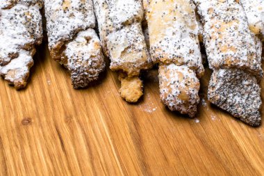 Bir haşhaş dolgulu kurabiye. Haşhaş tohumu ve pudra şekeri ile tatlı bisküvi. Ahşap zemin üzerine ev yapımı kurabiye