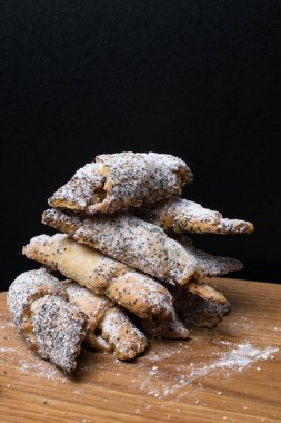 Bir haşhaş dolgulu kurabiye. Haşhaş tohumu ve pudra şekeri ile tatlı bisküvi. Ahşap zemin üzerine ev yapımı kurabiye