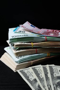 Kazık para: siyah arka plan üzerine kauçuk ile dolar ve Euro banknot