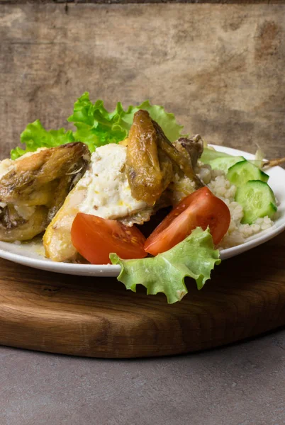 Булгур с курицей, сырыми помидорами, салат в белой тарелке. Угловой вид на деревенский бетонный фон . — стоковое фото