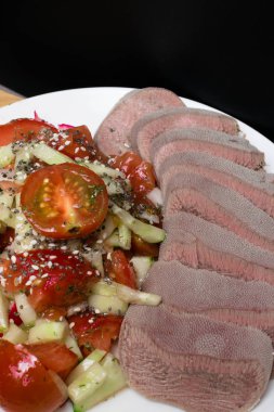 kesme ham dil ve salata marul, domates, salatalık, petrol, chia seesam tohumlar üzerinde beyaz plaka ile haşlanmış