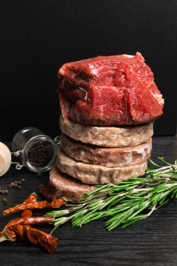 Ham Minced hamburger etli bitki ve baharat hazırlanan ızgara için biberiye, sıcak kırmızı biber, kara biber siyah ahşap tablo