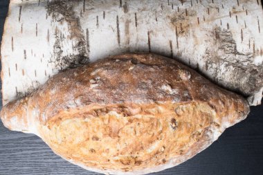 Taze ve lezzetli kepekli ekmek veya ahşap huş ağacı kesme tahtası için sağlıklı beslenme arka plan üzerinde somun