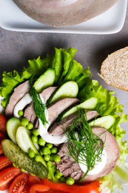 haşlanmış sebze domates biber salatalık marul bezelye mayonez ve ekmek beyaz tabakta diliyle