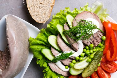 haşlanmış sebze domates biber salatalık marul bezelye mayonez ve ekmek beyaz tabakta diliyle