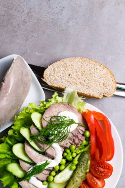 haşlanmış sebze domates biber salatalık marul bezelye mayonez ve ekmek beyaz tabakta diliyle